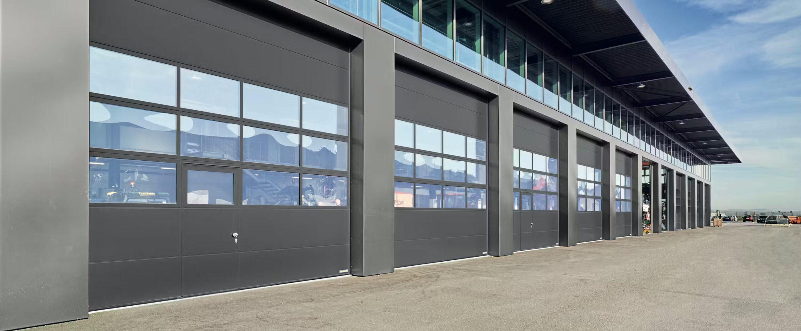 Industrie Sektionaltore Moderne Industrie-Sektionaltore bieten maximale Funktionalität und Effizienz für Werkhallen und Logistikzentren. Dank ihrer robusten Bauweise und großen Verglasungsflächen sorgen sie für Langlebigkeit, Energieeffizienz und optimale Lichtverhältnisse in industriellen Gebäuden.